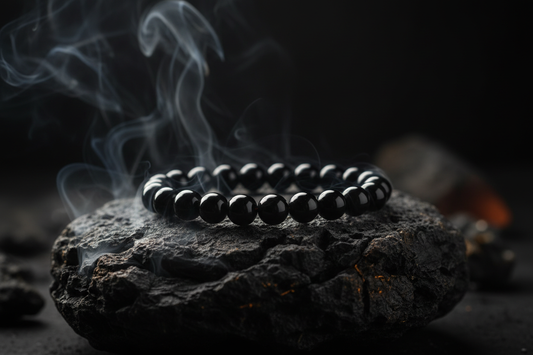 Black obsidian crystal bracelet on volcanic rock with sage smoke — Zenora Spirit